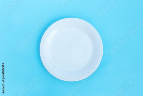 Empty plate isolated on blue background, after some edits.