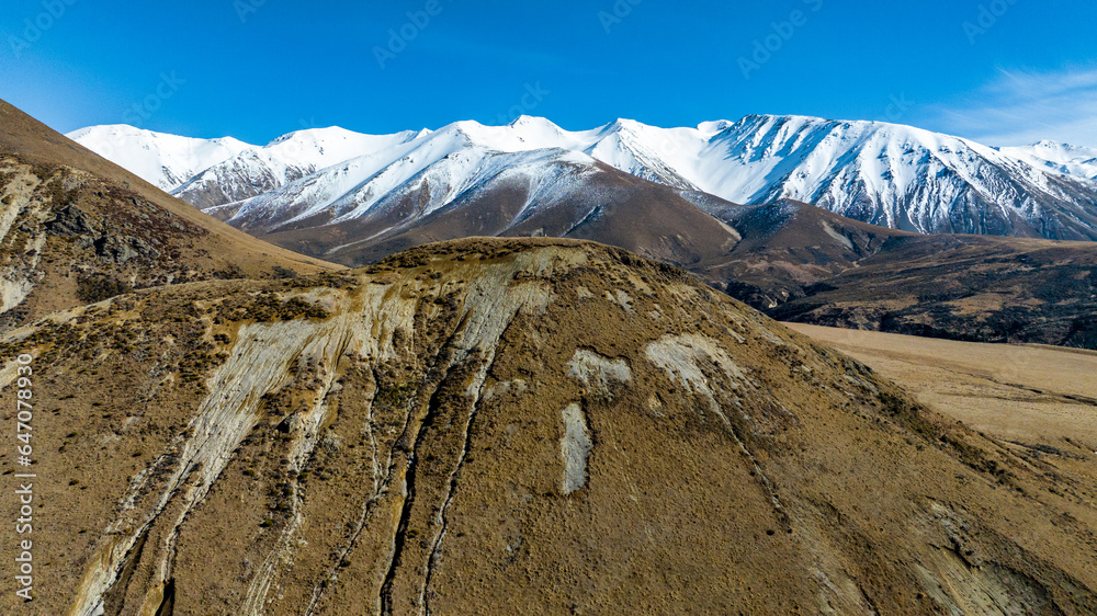 Snow capped mountains and lower hills with an arid  valley in between