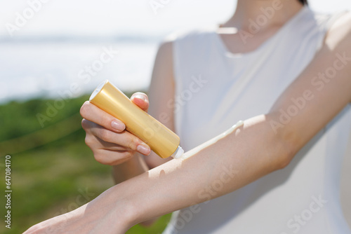 日焼け止めを手に塗る若いアジア人女性