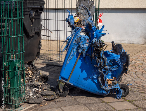 Blue garbage can after a fire, vandalism