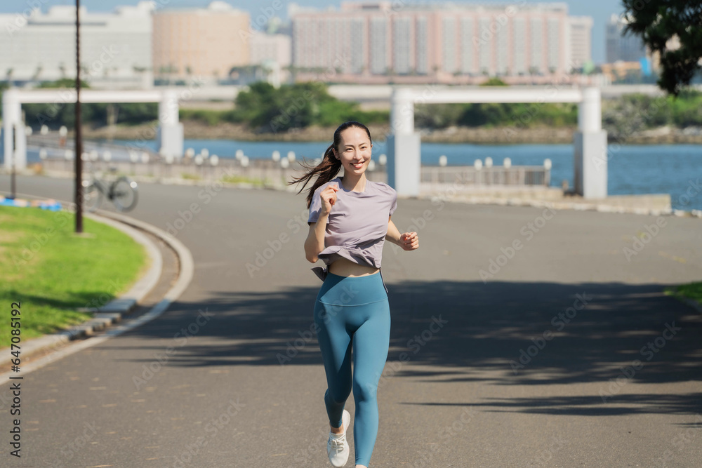 Fototapeta premium 屋外でジョギングする若いアジアの女性