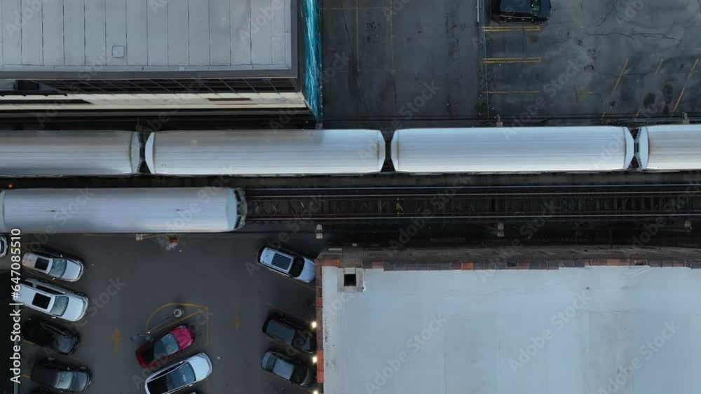 Inner city trains in United States city. Aerial descending shot over train tracks in downtown urban center. Transportation and commute theme. Second train going opposite direction.