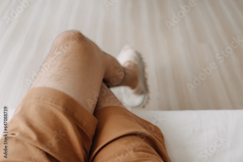 Top view of man sitting on sofa with crossing legs in cozy loft room.