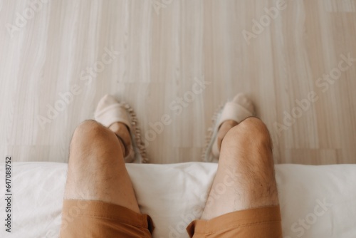 Top view of man sitting on sofa with crossing legs in cozy loft room. © Sevendeman