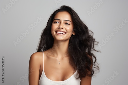 Closeup photo portrait of a beautiful young asian indian model woman smiling with clean teeth. Used for a dental ad. Isolated on light background.