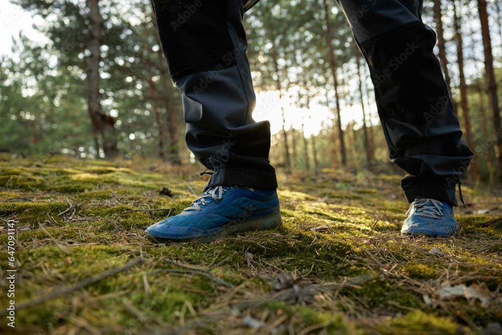 Closeup hiker foot in trekking boots walking in forest
