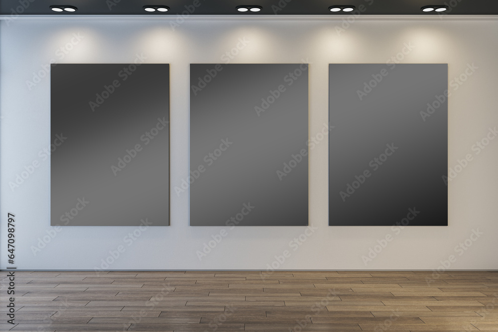 Fototapeta premium Modern museum or exhibition hall interior with clean illuminated black mock up frames on concrete wall and wooden parquet flooring. 3D Rendering.