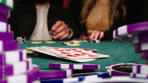 Casino. Game chips and dice lie on the table against the background of business players. Game chips for betting in gambling. Dice. Poker chips.