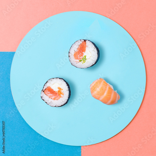 Japanense sushi rolls with salmon on a plate, top view