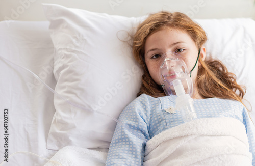 Bild auf Leinwand Portrait of little girl suffering from pneumonia lying in hospital bed with oxygen mask
