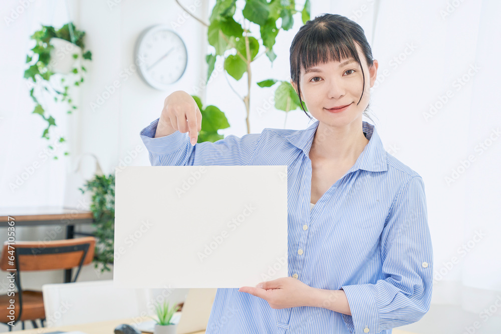 ホワイトボードを持つ自宅で仕事をする女性　立ちポーズ