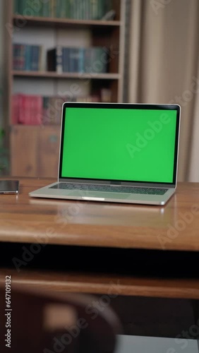 Laptop with Mock Up Green Screen Chroma Key Display Standing on Desk In Loft-style Office