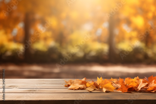 Beautiful colourful natural autumn background for presentation. Fallen dry orange leaves on wooden boards against the backdrop of a blurry autumn park