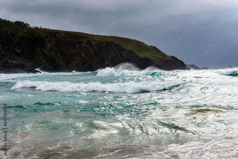 Beautiful landscape with the sea with waves and turquoise blue waters. It's summer but with bad weather and beautiful light. Esteiro beach, A Coruña, Spain.
