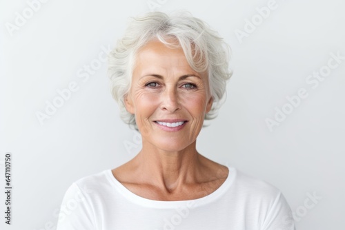 Portrait of a smiling senior woman looking at camera over white background