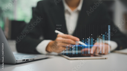 A man holding holographic graphs and stock market statistics gain profits. Concept of growth planning and business strategy. Corporate strategy for finance, operations, sales, marketing.
