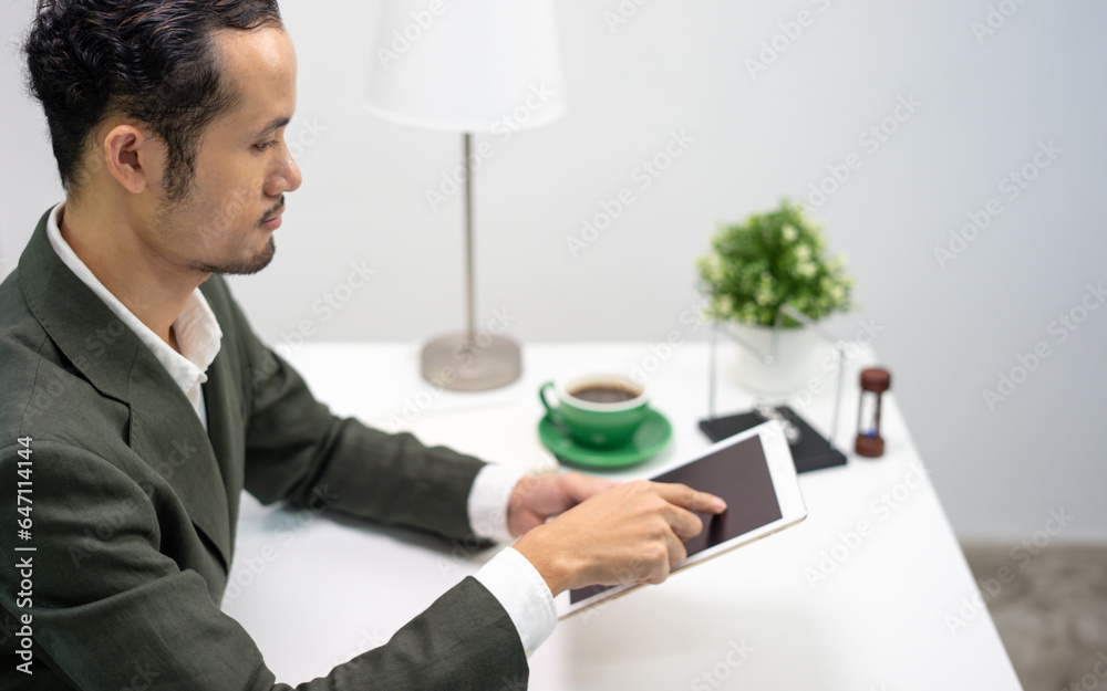 Businessman using digital tablet at desk in office
Businessman using digital tablet at desk in office
