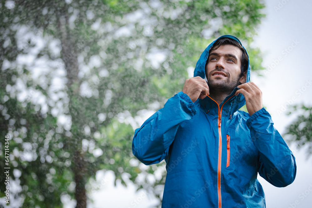 man in a raincoat in the rain in a rainy day in the park, the concept of the rainy season man in a raincoat in the rain in a rainy day in the park, the concept of the rainy season