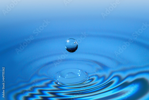 Clear aqua water droplet splashing in concentric circles, capturing refreshing purity.