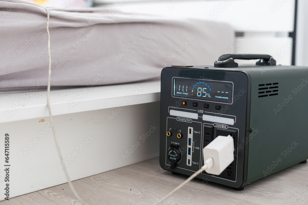 Portable power station charging devices on table in living room, closeup Portable power station charging devices on table in living room, closeup
