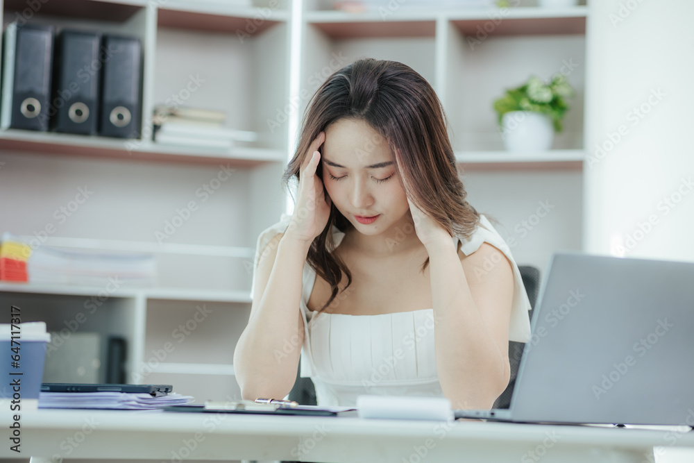 Asian woman stressed while working in the office Asian business woman who is tired from work feeling sick at work Asian woman stressed while working in the office Asian business woman who is tired from work feeling sick at work