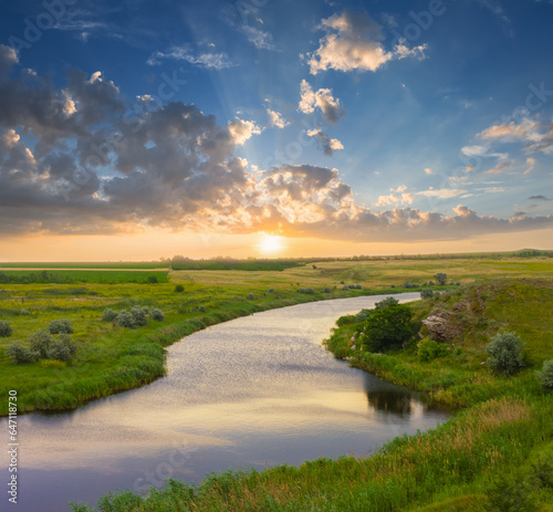 calm  river flow among green prairies  at the sunset