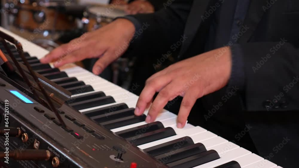 The hands of a musician man playing the electronic piano during a concert The hands of a musician man playing the electronic piano during a concert