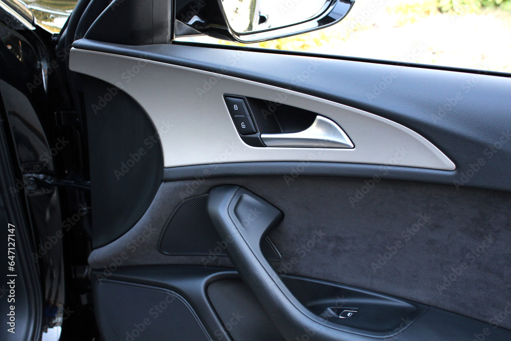 Elegant design of luxury car door trim. Door trim elements and door handle with rear view mirror. View from inside the car. Side rear-view mirror on a modern car. Luxury car door interior trim Elegant design of luxury car door trim. Door trim elements and door handle with rear view mirror. View from inside the car. Side rear-view mirror on a modern car. Luxury car door interior trim