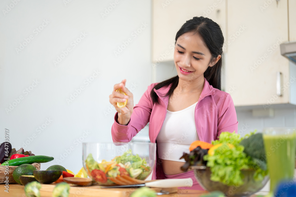 A happy Asian woman is squeezing a lemon on her salad, making her healthy breakfast in the kitchen. A happy Asian woman is squeezing a lemon on her salad, making her healthy breakfast in the kitchen.