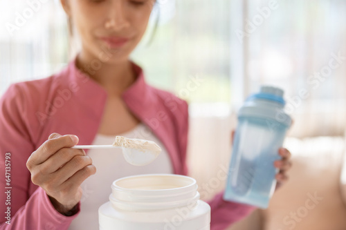 Foto Close-up image of a healthy Asian woman in sportswear making her protein shake after a workout