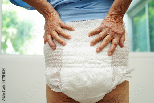 Asian senior woman patient wearing adult incontinence diaper pad in hospital. photo