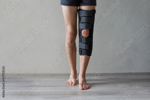Fotografie Patient standing with knee brace support after do posterior cruciate ligament surgery