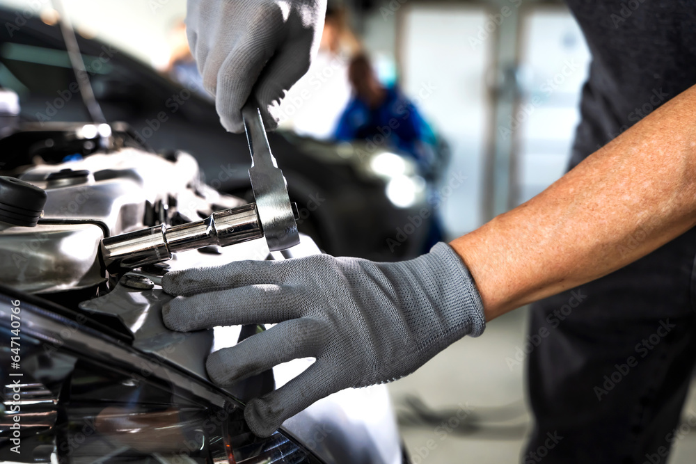 Auto mechanic using wrench working and fixing car in auto repair Auto mechanic using wrench working and fixing car in auto repair