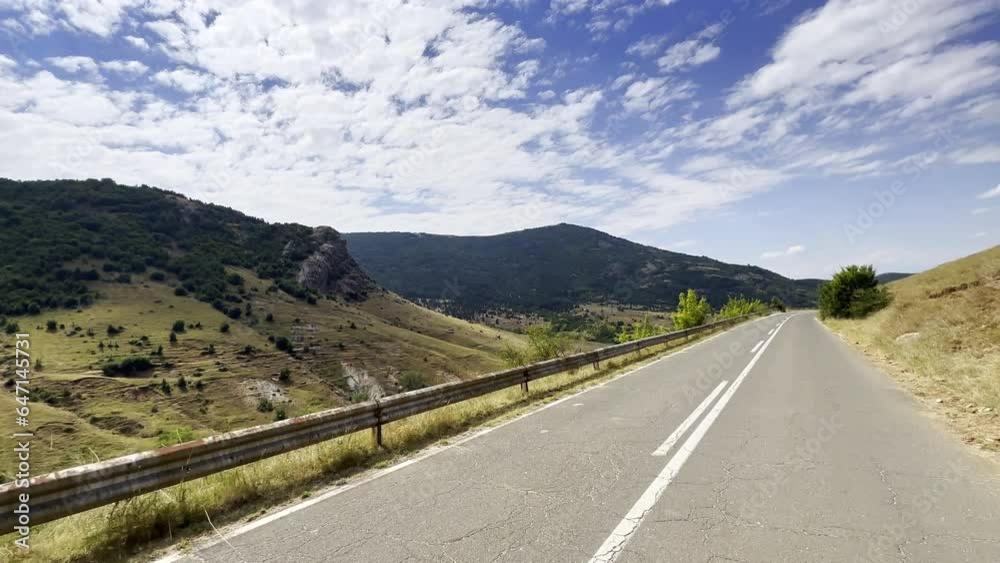 POV road, hills, dry grass covered slopes, clouds POV road, hills, dry grass covered slopes, clouds