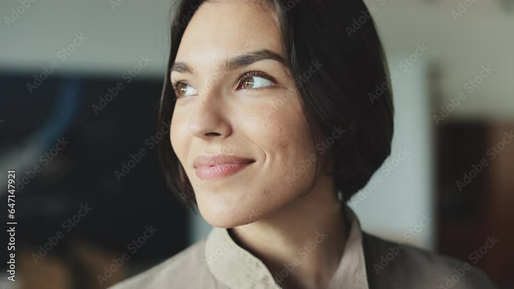 Close up of pretty woman with short dark hair and natural make up thoughtfully looking away and gently smiling. Young female aviator with happy facial expression dreaming of her first flight. Close up of pretty woman with short dark hair and natural make up thoughtfully looking away and gently smiling. Young female aviator with happy facial expression dreaming of her first flight.