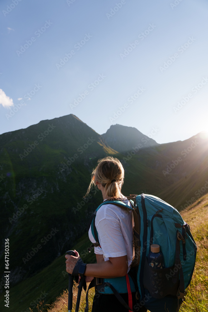 Girl with a backpack hiking in the evening light