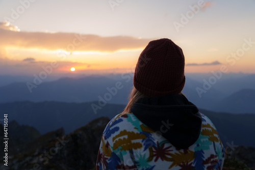 Girl watching the sunrise on the mountain top of Piz Fess photo