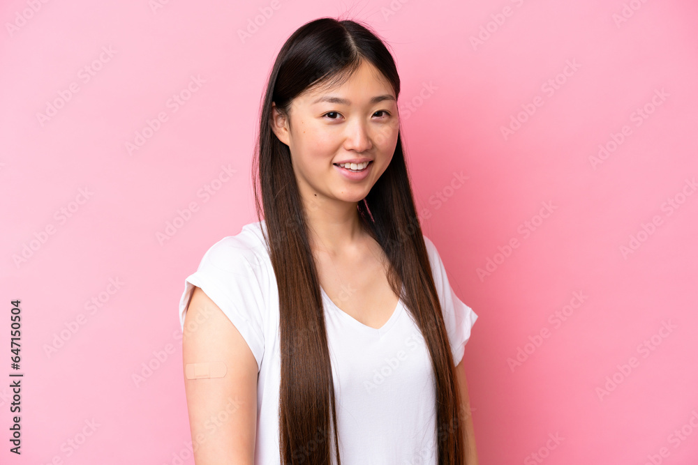 Young Chinese woman wearing a band aids isolated on pink background smiling a lot Young Chinese woman wearing a band aids isolated on pink background smiling a lot