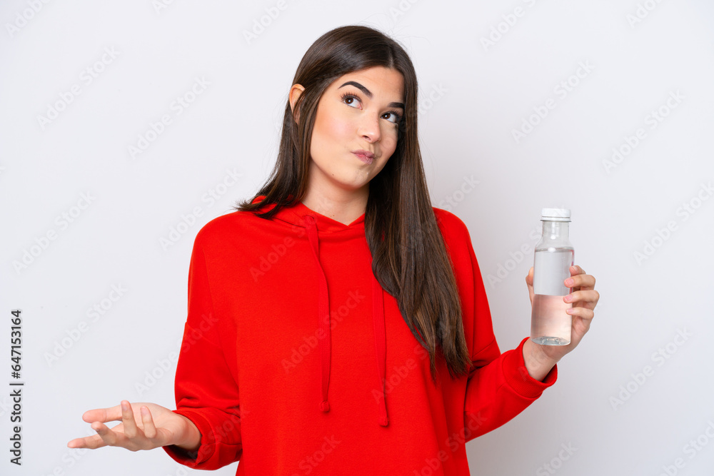 Young Brazilian woman with a bottle of water isolated on white background making doubts gesture while lifting the shoulders Young Brazilian woman with a bottle of water isolated on white background making doubts gesture while lifting the shoulders
