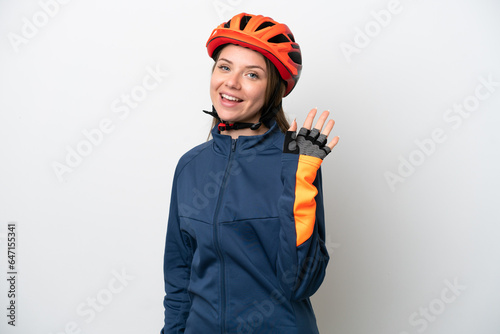 Young cyclist Lithuanian woman isolated on white background saluting with hand with happy expression