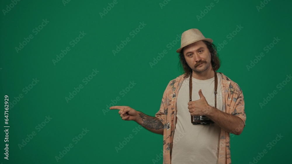Man in casual clothing and straw hat with old film camera pointing at the empty area, shows thumbs up. Space to insert advertising. Man in casual clothing and straw hat with old film camera pointing at the empty area, shows thumbs up. Space to insert advertising.