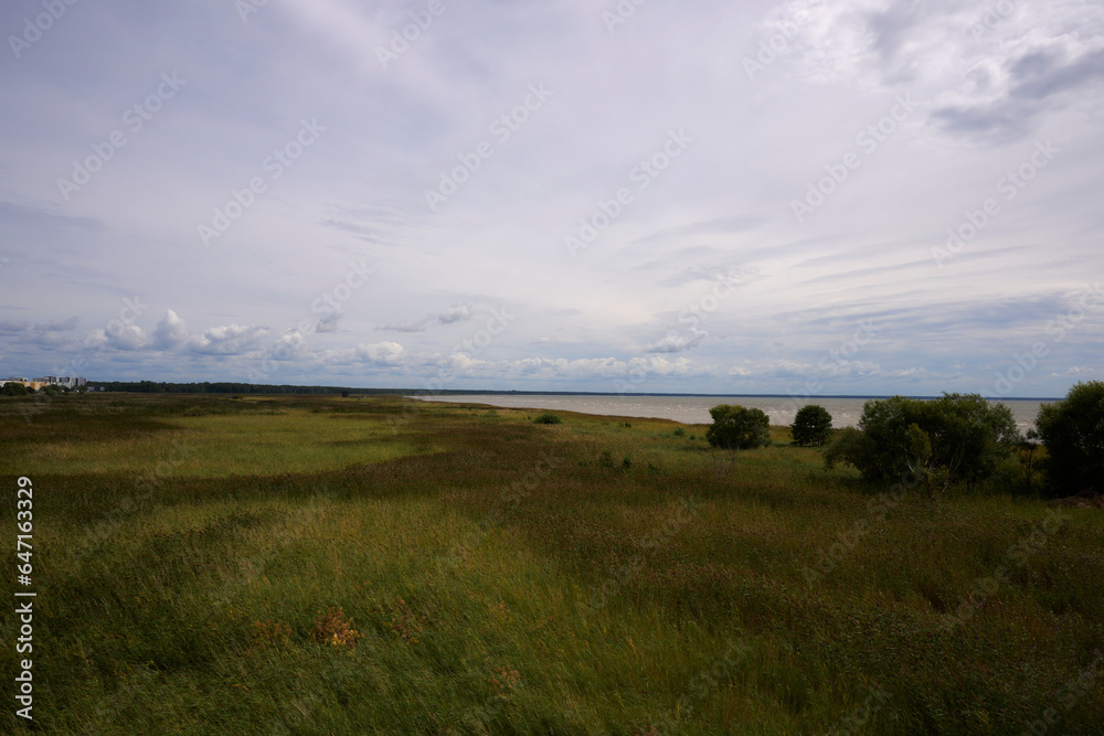landscape with green beach on the see and clouds
