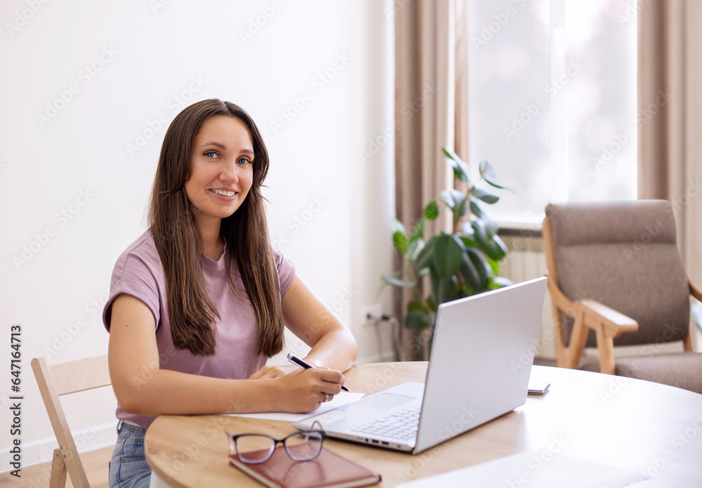 Portrait of a beautiful young woman sitting at the table with laptop
Portrait of a beautiful young woman sitting at the table with laptop