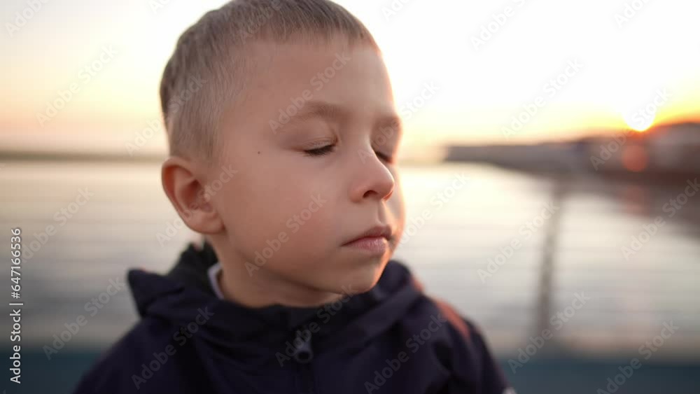 Caucasian little boy looking up at sky in nature outdoor with curious or carefree expression. Beautiful facial features and brown eyes glow in sun. Portrait of face profile close up. Leisure activity. Caucasian little boy looking up at sky in nature outdoor with curious or carefree expression. Beautiful facial features and brown eyes glow in sun. Portrait of face profile close up. Leisure activity.