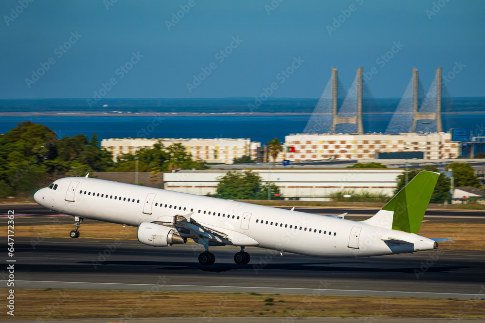Airplane taking off or landing on runway of Lisbon airport on sunny