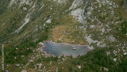 A small lake in the mountains and a small mountain hut next to it. Lake Mässersee in the Binn Valley. Beautiful Swiss alpine country photo