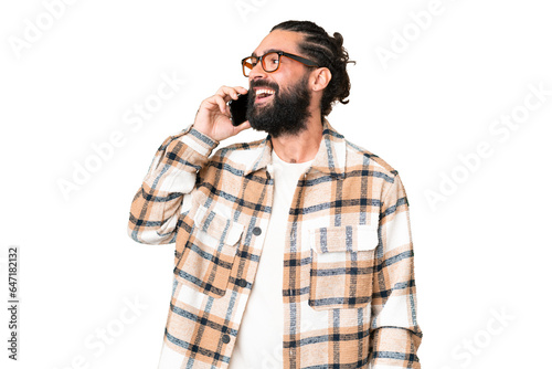 Young man with beard over isolated chroma key background keeping a conversation with the mobile phone