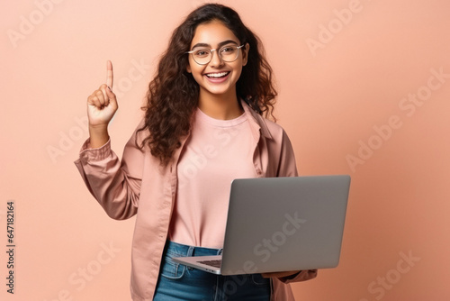 Young college girl using laptop and pointing on up side