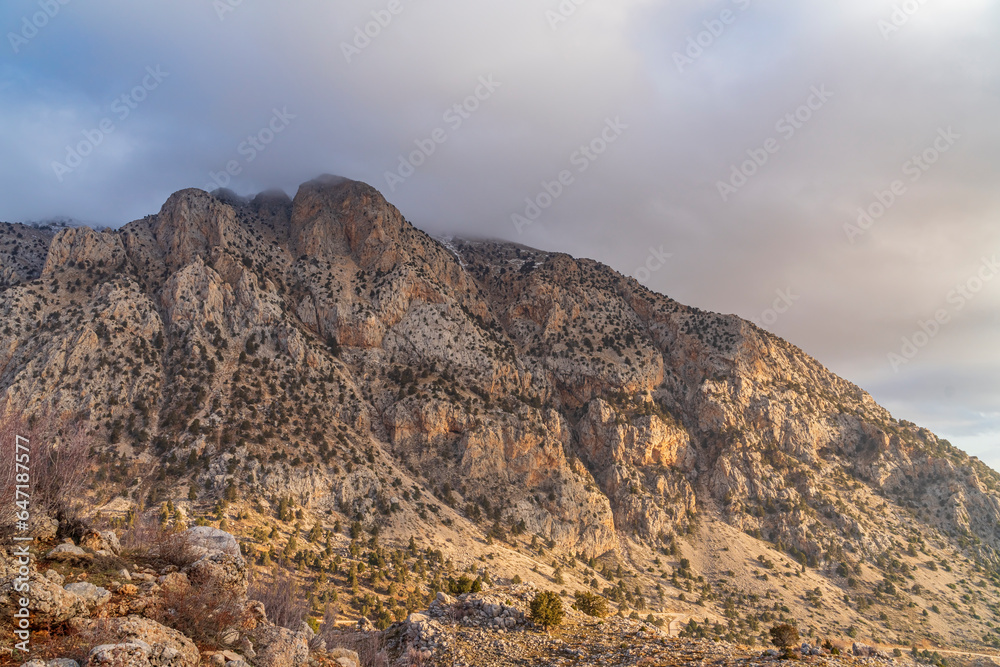 barren mountains with clouds on top