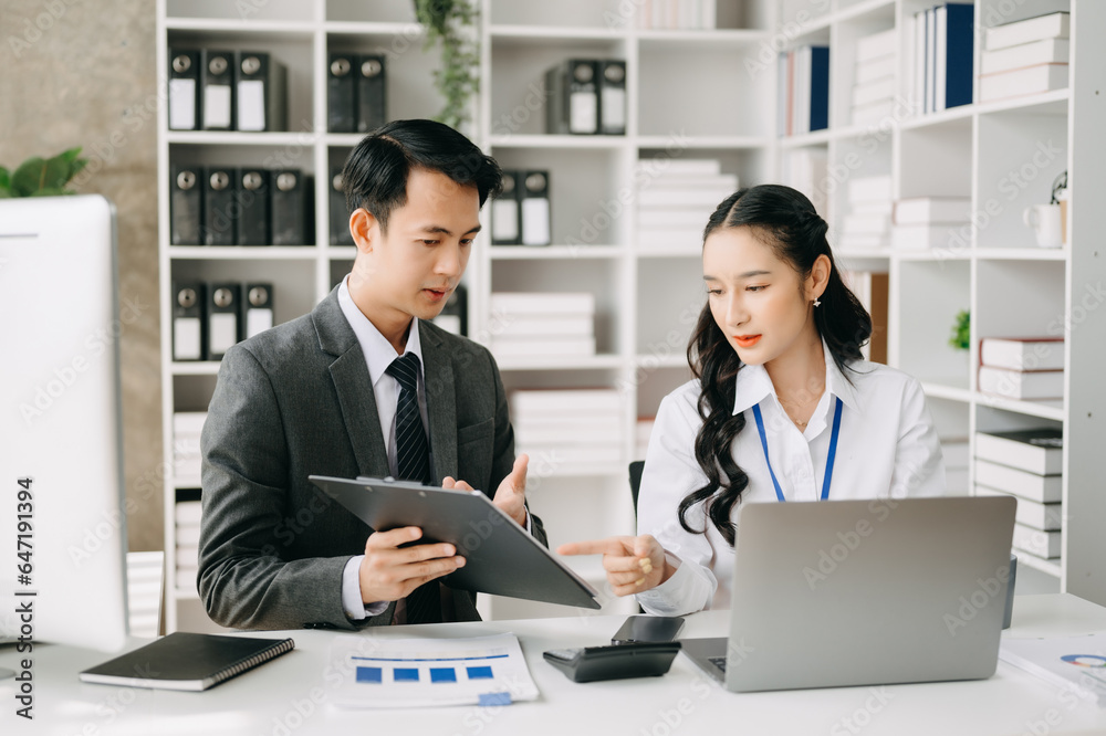 Two business workers talking on the smartphone and using laptop at the office. Two business workers talking on the smartphone and using laptop at the office.